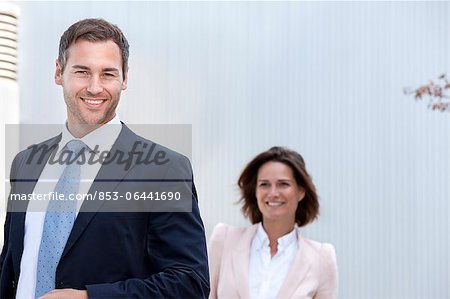 Smiling businessman and businesswoman outdoors