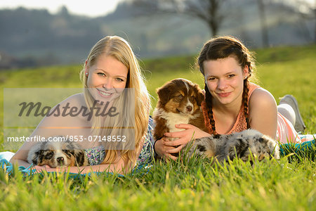Two young women with australian sheperd puppy, Bavaria, Germany, Europe