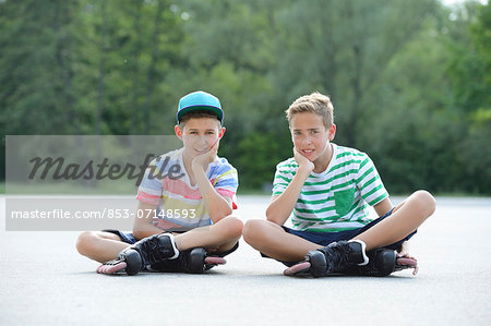 Two boys with in-line skates on a sports place