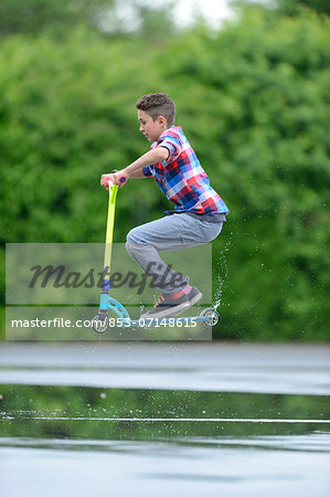 Boy with scooter on a rainy day