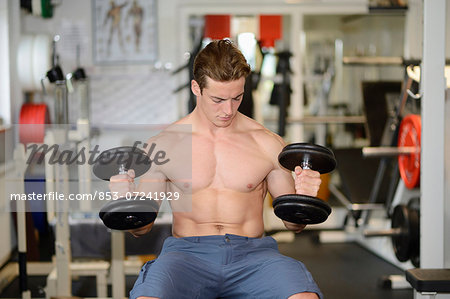 Young man exercising in fitness center
