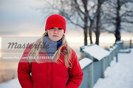 Young woman talks on cell phone at the Baycrest pullout on the sterling highway near Homer, Alaska during Winter