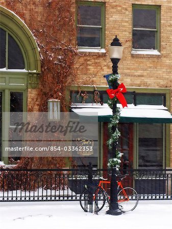 Bicycle leaning against a lamp post decorated for Christmas during Winter in Bozeman, Montana