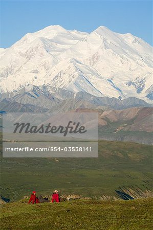 Two hikers view McKinley from tundra at Eielson visitor center summer Denali National Park Alaska