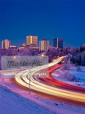 Twilight view of traffic on Minnesota Blvd. with downtown Anchorage in the background, Southcentral Alaska, Winter