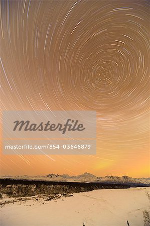 Night time view of star trails over Mt. McKinley with Northern Lights in the background, Denali State Park, Southcentral Alaska, Winter