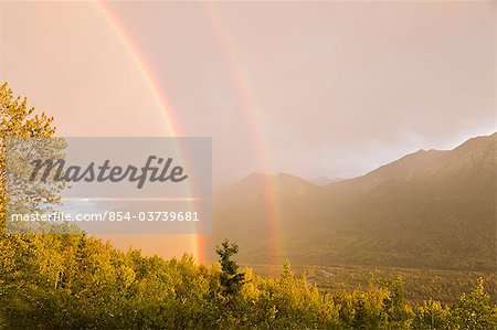 Sunset view of a double rainbow arching over Eagle River Valley after a passing storm, Southcentral Alaska, Summer