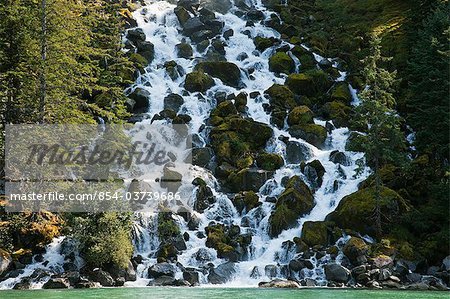 A waterfall cascades over moss covered boulders in Fords Terror Fjord in Tracy Arm-Fords Terror Wilderness, Tongass National Forest, Inside Passage of Southeast Alaska, Summer