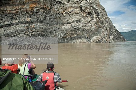 A family floats in a raft along Calico Bluffs near the village of Eagle on the Yukon River, Interior Alaska, Summer