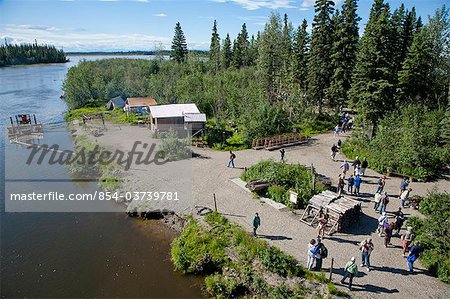 Tourists on Riverboat Discovery tour walk about Indian village along Chena River, Fairbanks, Interior Alaska, Summer