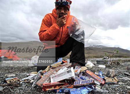 Backpacker eats snacks  at base camp along the Hulahula River, Brooks Range, ANWR, Arctic Alaska, Summer