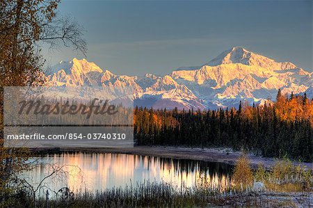 View of southside Mount McKinley and Mount Hunter at sunrise with small lake in foreground, Southcentral Alaska, Autumn, HDR image