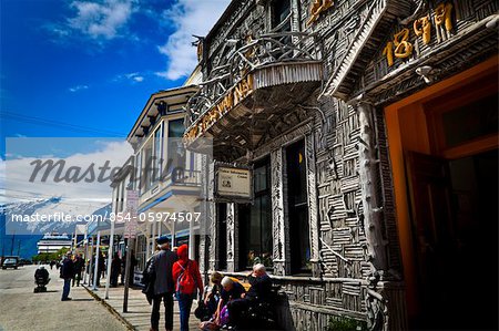 Tourists at the historic Arctic Brotherhood Hall building of Visitor Information Center, a cruise ship docked at end of street, Skagway, SE Alaska on an early summer, sunny day.