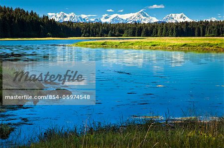 The meandering Bartlett River beneath snow covered Fairweather Mountains on a sunny day, Glacier Bay National Park & Preserve, Southeast Alaska, Summer