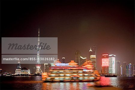 Skyline of Pudong at night with tour boats on Huangpu River,Shanghai,China