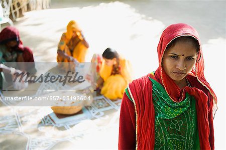 Close-up of a mid adult woman thinking with rangoli in the background, Jodhpur, Rajasthan, India