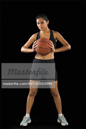Portrait of a young woman holding a basketball