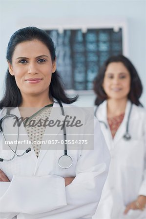 Female doctor smiling with her arms crossed, Gurgaon, Haryana, India