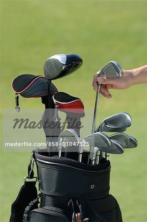 Hand reaching for club from golf bag