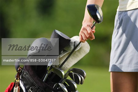 Female golfer reaching for club