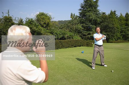 Men playing golf at golf course