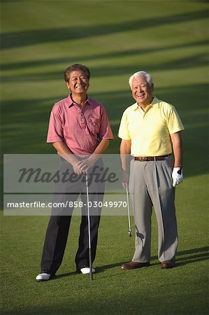 Front view of smiling friends standing at golf course