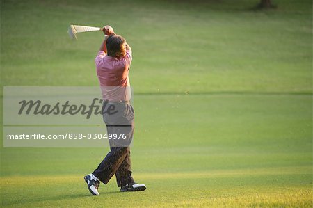 Side view of a golfer in action while hitting a golf shot