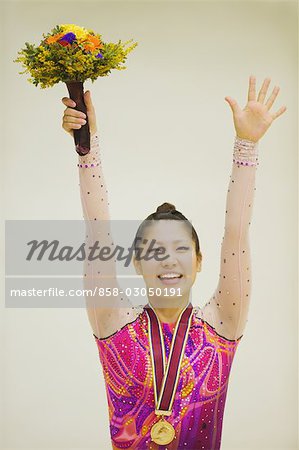 Gymnastic winner posing with medal and bouquet