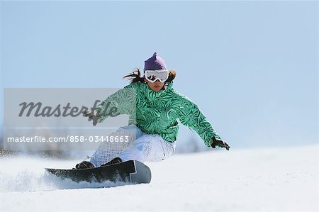 Woman doing Heelside Turn while Snowboarding