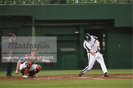 Batter hitting ball while playing baseball