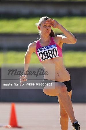 Young Female Athlete Performing High Jump