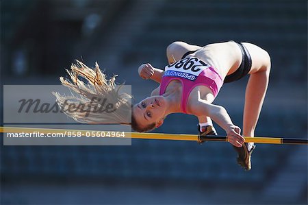 Young Female Athlete Performing High Jump