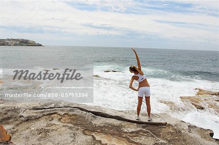 Young Woman Exercising at Seashore