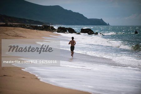 Young Man Running On The Beach
