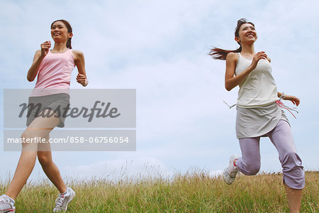 Friends Jogging On Grass