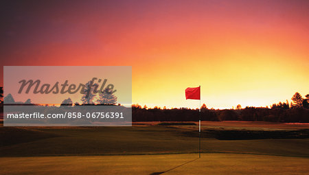 Golf Flag On Green With Red Sky