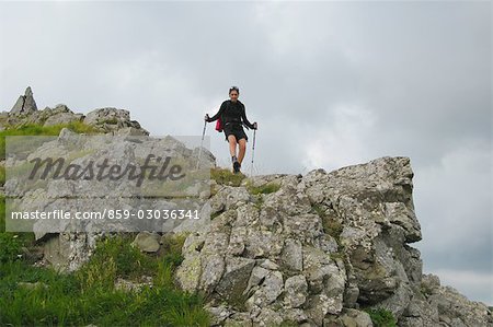 Woman backpacking along with hiking sticks