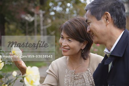 Middle-aged couple looking at flower