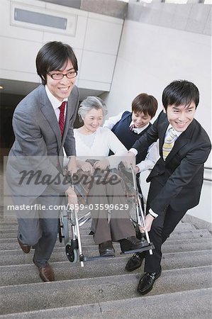 People Helping  Woman On Wheelchair