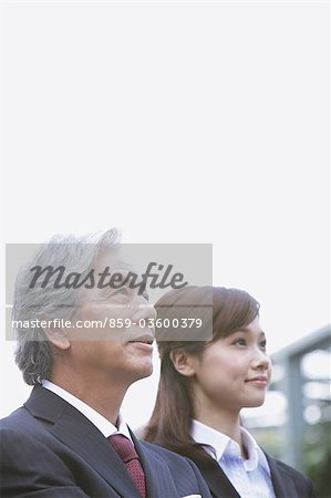 Businessman And Businesswoman Looking Up