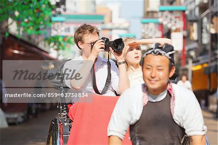 Young Couple Sitting In Rickshaw In Asakusa, Japan