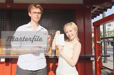 Couple With Fortune Telling Paper In Temple