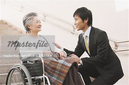Young-Adult Man Talking With Elderly Woman