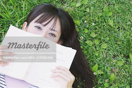 Young Woman Covering Her Face With A Book