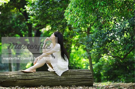 Japanese Young Woman Sitting on Tree Trunk