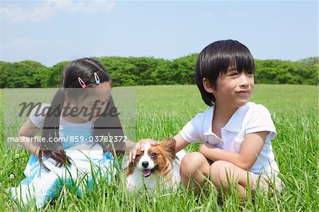 Girl and Boy Playing with Pet Dog