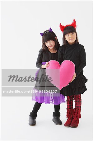 Two Girls In Halloween Costume Holding Heart