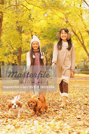 Girls With Their Dogs In Autumn Foliage
