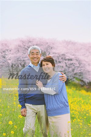 Middle-Aged Couple Standing In Flowerbed