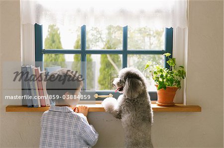 Boy With His Pet Standing By Window